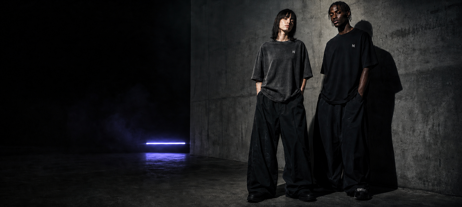 Dos modelos vistiendo playeras oversized NOCTRA con el símbolo N